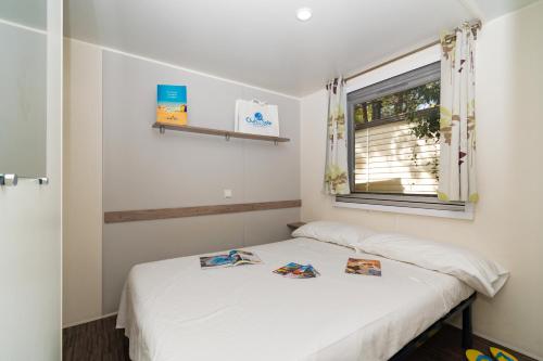 a bedroom with two beds and a window at Club del Sole Adriano Family Collection in Punta Marina