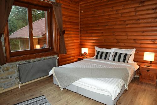 a bedroom with a bed in a log cabin at Moiata Kashta Villa in Popovi Livadi