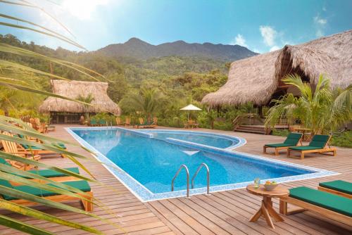um resort com uma piscina e um deque com cadeiras em Senda Koguiwa em El Zaino