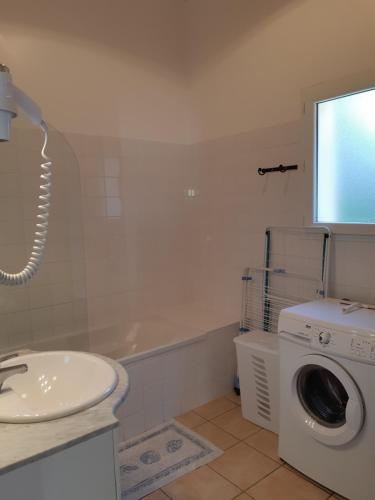 une salle de bain avec une machine à laver et un lavabo dans l'établissement les hauts de sarlat n7, à Sarlat-la-Canéda