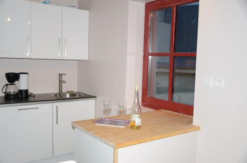 a kitchen with a table with wine glasses and a window at LES CHALETS D'AURE. in Aragnouet