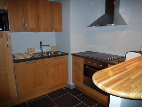 a kitchen with wooden cabinets and a sink and a counter at LES CHALETS D'AURE. in Aragnouet