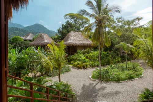 uma vista para um resort com palmeiras e cabanas em Senda Koguiwa em El Zaino