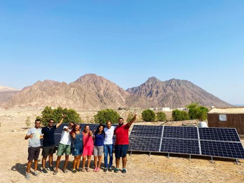 a group of people standing in front of solar panels at SakraTah Camp - eco friendly in Taba