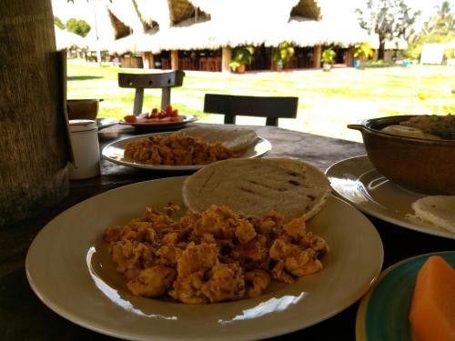 a table with two plates of food on it at Hotel Brisas La Gaviota Mariquit-Tolima in Mariquita