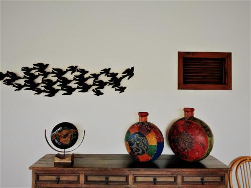 two vases sitting on top of a wooden table at Hotel Brisas La Gaviota Mariquit-Tolima in Mariquita