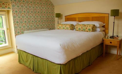 a bed with a white bedspread and a blue comforter at Ravenhill House in Belfast