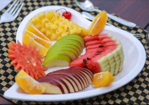 a white plate of fruit on a table at Blue Diamond Resort in Trincomalee