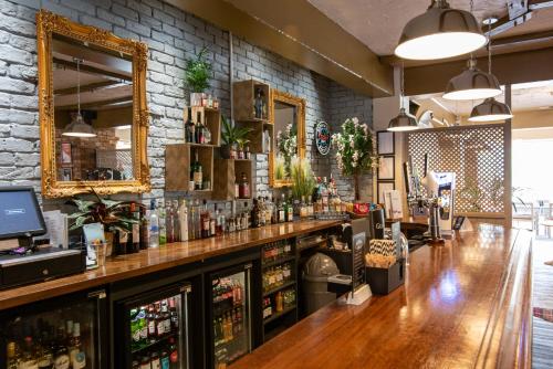 a bar in a restaurant with a stone wall at Dragonfly Hotel Bury St Edmunds in Bury Saint Edmunds