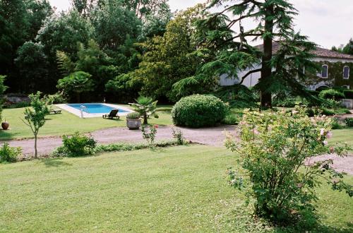 un jardin avec une piscine et une maison dans l'établissement Chateau De Mesnac, à Mesnac