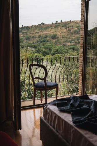 a room with a chair and a window with a view at Leano Agriresort in Piazza Armerina