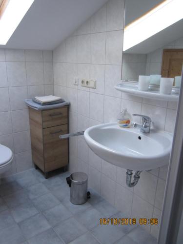 een witte badkamer met een wastafel en een spiegel bij Raffaela Maderspacher in Oberammergau