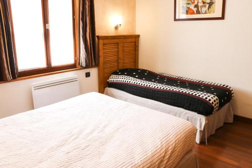 a bedroom with two beds and a window at Auberge de la Vieille Ferme in Le Meux