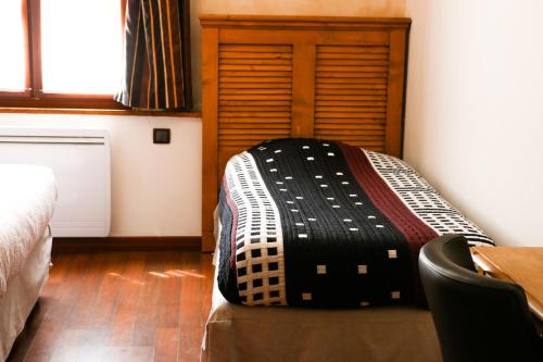 a bedroom with a bed and a wooden door at Auberge de la Vieille Ferme in Le Meux