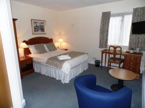 a hotel room with a bed and a blue chair at Yarnfield Park Training And Conference Centre in Stone