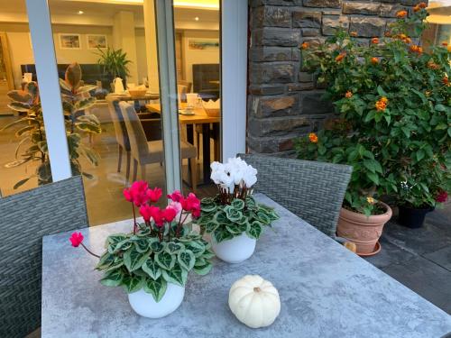two white vases with flowers and a pumpkin on a table at Weinbergs Loge in Ernst