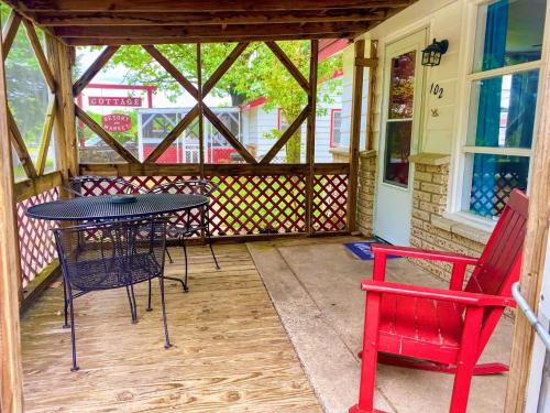 a screened in porch with a table and two chairs at The Cottage Resort in Branson