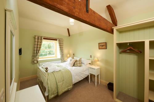 a bedroom with a bed and a window at Autumn Cottage in Kendal