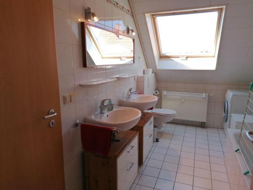 La salle de bains est pourvue de 2 lavabos et de toilettes. dans l'établissement Ferienwohnung Suedbalkon, à Friesenheim