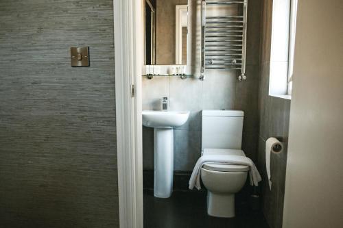 a bathroom with a toilet and a sink at Arthur's Bar & Accommodation in Southport