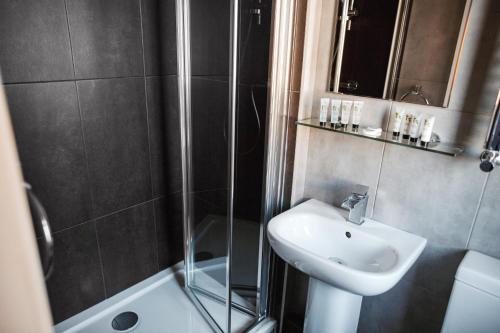a bathroom with a sink and a shower and a sink at Arthur's Bar & Accommodation in Southport