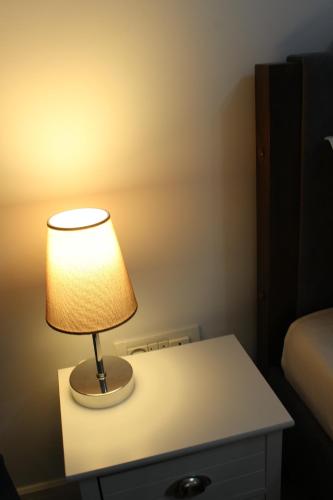 a lamp sitting on a table in a bedroom at Luxury City Center Apartment - Bucharest Railways Station in Bucharest
