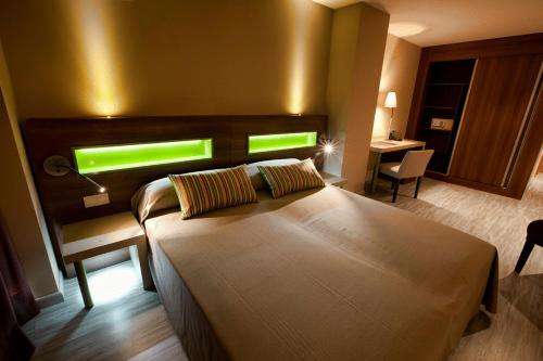 Hotel Allon Mediterrania في فايلاجويوسا: غرفة نوم بسرير كبير ومكتب ونافذة