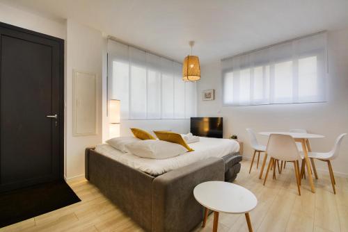 Un dormitorio con una cama y una mesa y sillas. en L'indépendant de la rue du Tapis Vert - Appt Nancy, en Nancy