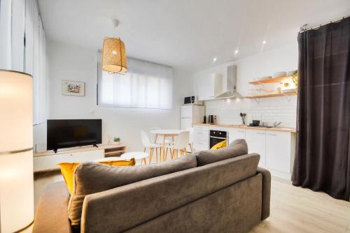 Una sala de estar con un sofá y una cocina. en L'indépendant de la rue du Tapis Vert - Appt Nancy, en Nancy