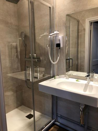 a bathroom with a sink and a shower at Hotel La Villa Fleurie in Beaune
