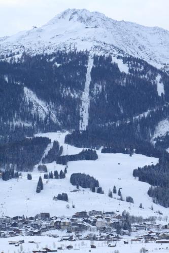 a snow covered mountain with a town and a river at Am Sonnenfels in Lermoos