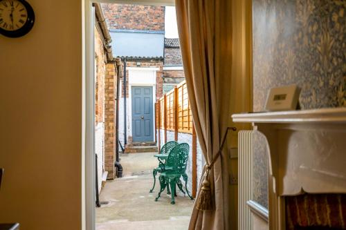 a hallway with two green chairs and a blue door at Victoria Cottage in York