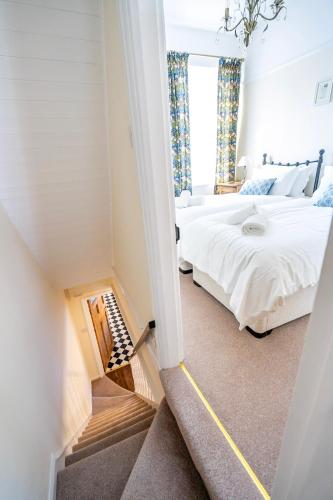 a bedroom with a white bed and a staircase at Victoria Cottage in York