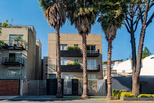 a building with palm trees in front of it at Suites Copérnico Polanco Anzures in Mexico City