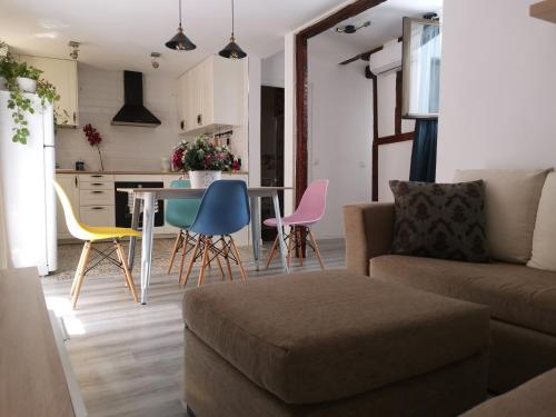 een woonkamer en een keuken met een bank en stoelen bij Casa Manuela Más que una Casa un Hogar in Toledo