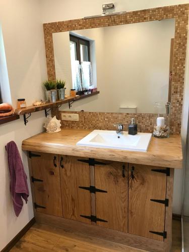 a bathroom with a sink and a mirror at DOMEK POD DĘBEM in Mielnik