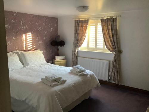 a bedroom with a bed with two towels on it at Brook Lodge Country Cottage in Doncaster