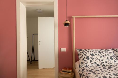 a bedroom with a bed and a pink wall at Da Coco - Rooms in Padova