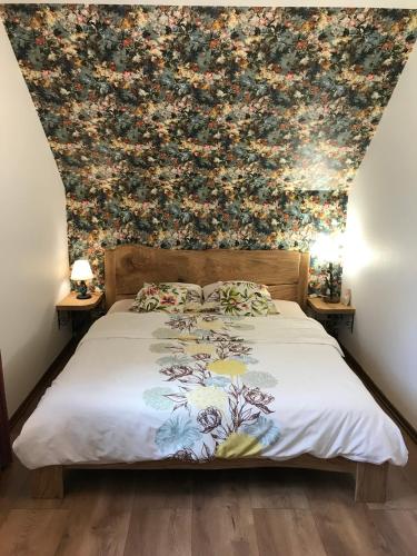 a bedroom with a bed with a floral wallpaper at DOMEK POD DĘBEM in Mielnik