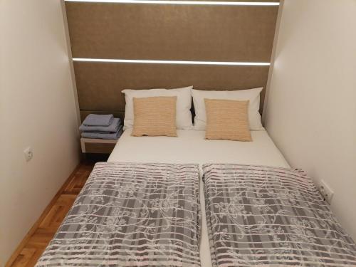 uma pequena cama num pequeno quarto com uma cama sidx sidx em Carmen deluxe em Novi Sad