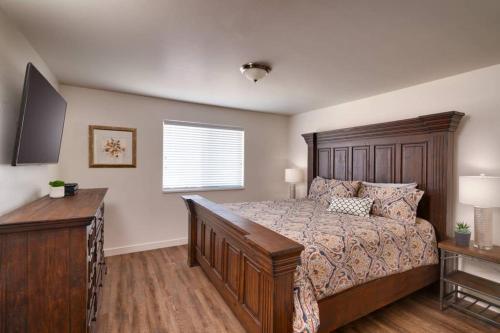 a bedroom with a bed and a dresser and a window at 5C Sweet RedCliff Condo, Pool & Hot Tub in Moab