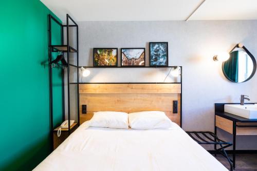 a bedroom with a large bed and a sink at Ibis Pau Centre in Pau