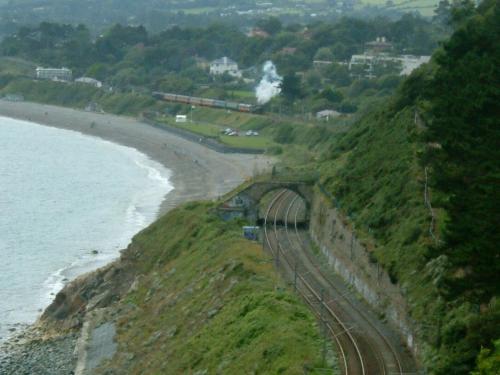 a train on the tracks next to the beach at Claremont House in Dun Laoghaire