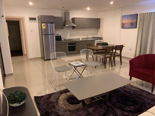 a kitchen and living room with a table and chairs at The Gallery Luxury Apartments in Accra
