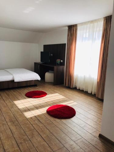 1 dormitorio con 2 alfombras rojas en el suelo en Pensiunea Montana Borșa MM en Băile Borşa