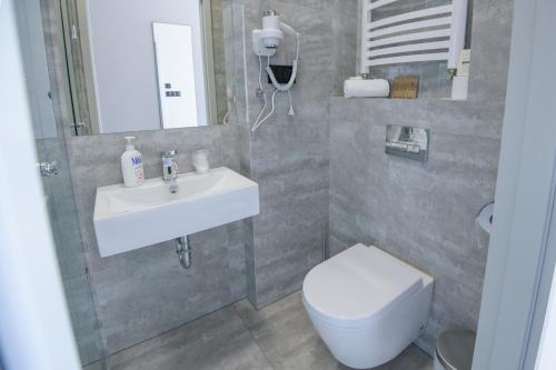 a bathroom with a white sink and a toilet at Hotel Węgierki in Września