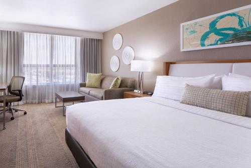 a hotel room with a large bed and a couch at Holiday Inn Miami West - Airport Area by IHG in Hialeah Gardens