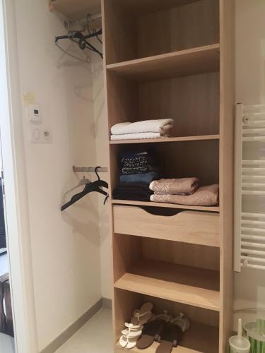 a walk in closet with wooden shelves and shoes at Clos des lys in Vittel