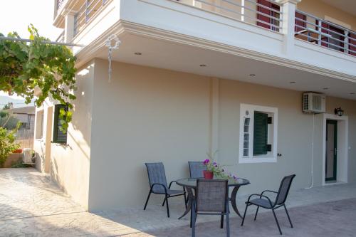 a patio with a table and chairs next to a building at Tsoutsis Apartments in Marantochori