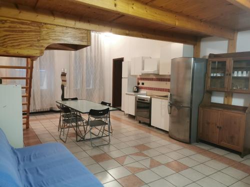 a kitchen with a table and a stainless steel refrigerator at Residence La Lanterna in Genova